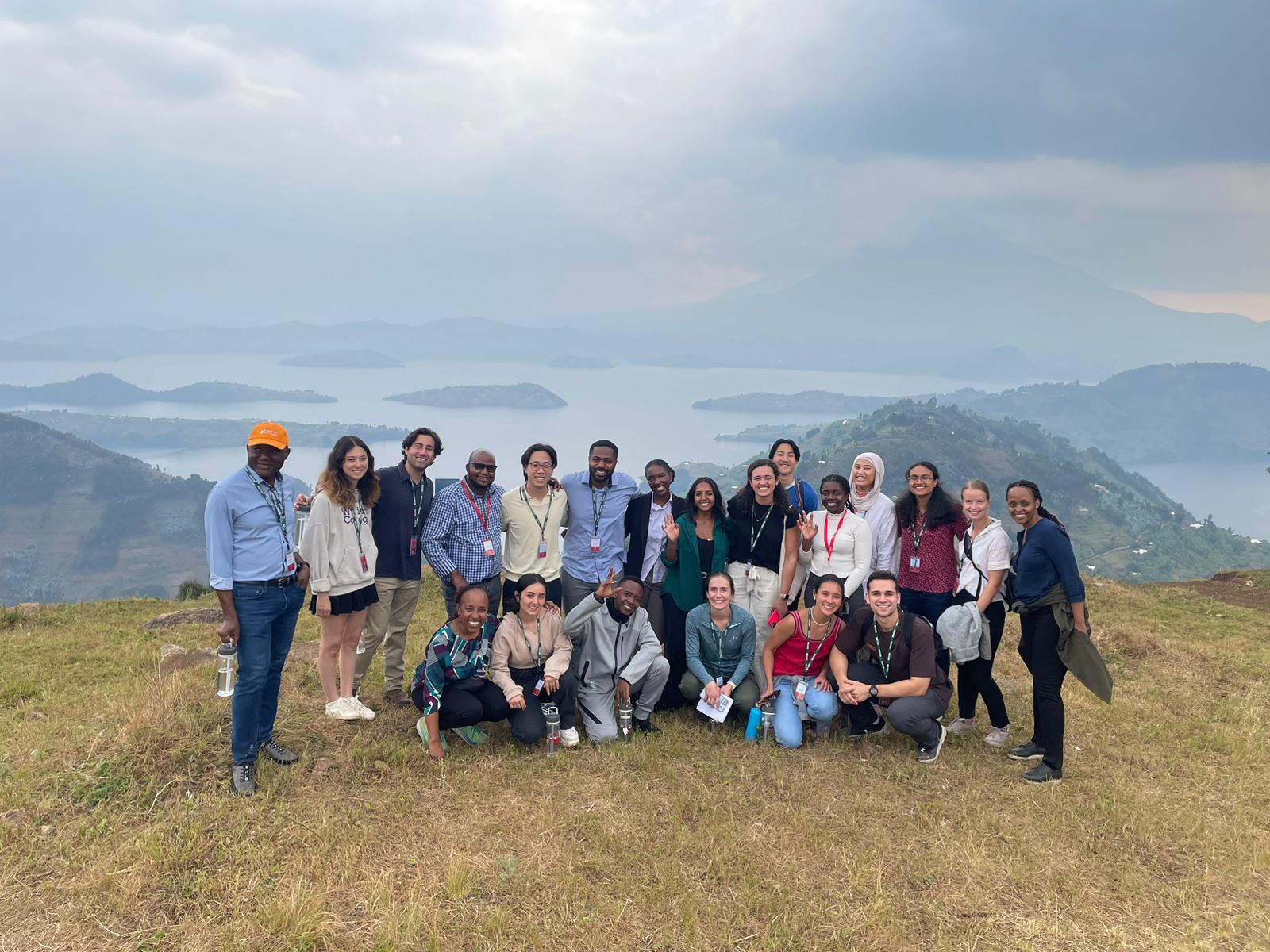 Group of faculty and staff on hilltop with water in background in Rwanda